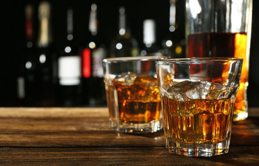 Glasses of whisky on wooden bar closeup