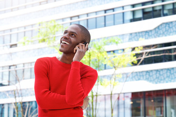 smiling young man talking on mobile phone in the city