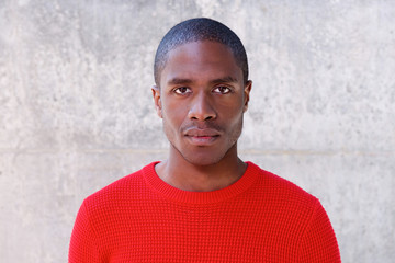 Young african american man in red sweater staring