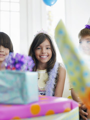 Girl and guests with birthday presents in foreground