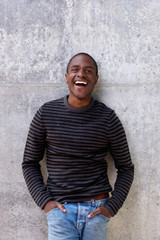 Fototapeta premium cheerful african american man in sweater with hands in pockets