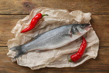 Raw fish with pepper on wooden table