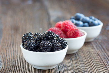 Fresh berries in bowls on a rustic wooden table