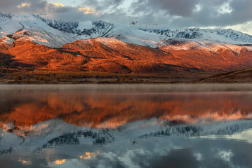Fototapeta na wymiar mountains lake snow reflection sunrise