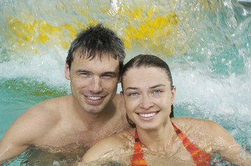 Closeup portrait of a smiling young couple in swimming pool