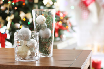 Glass vases with Christmas decoration on wooden table