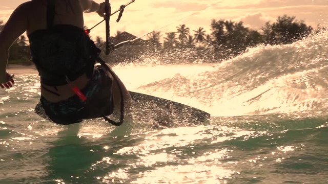 SLOW MOTION CLOSEUP: Extreme kiter girl kiteboarding fast and splashing water