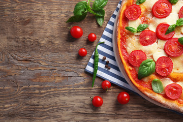 Delicious pizza on kitchen table
