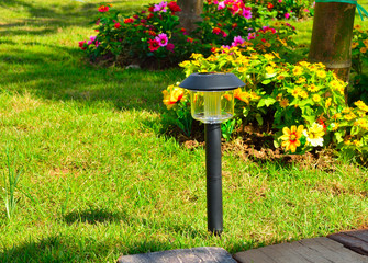 Solar-powered lamp on garden background
