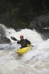 View of a man kayaking in rough river