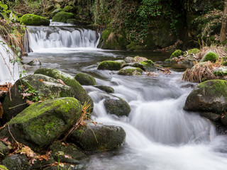 cascada entre piedras con musgo