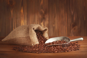 Purse with roasted coffee beans on wooden background