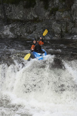 View of a woman kayaking in rough river