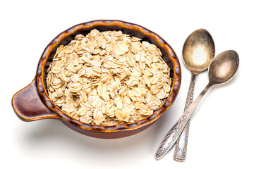 Dry rolled oat flakes oatmeal in a old bowl