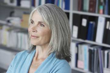 Closeup of a smiling middle aged businesswoman looking away in office