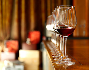 Row of glasses with red wine on bar counter
