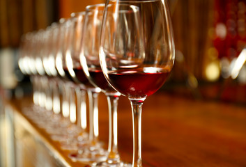 Row of glasses with red wine on bar counter