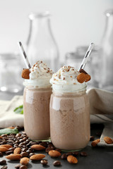 Tasty milk shake cocktails with coffee beans and almond nuts on table