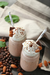 Tasty milk shake cocktails with coffee beans and almond nuts on table
