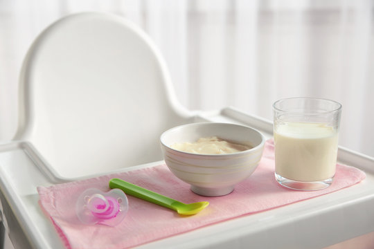Highchair with healthy baby food at home. Child feeding concept