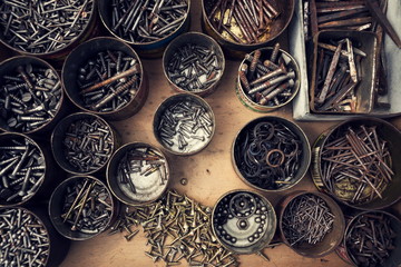Fototapeta na wymiar Filtered screws and bolts in tin can on wooden background