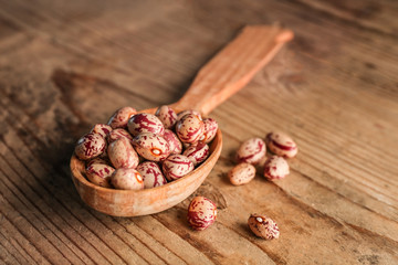 Closeup of wooden spoon with beans on table
