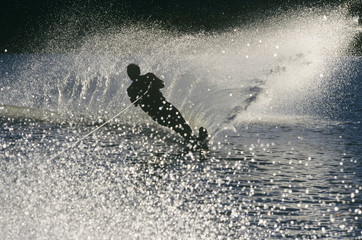Full length of a silhouette male water skier in action