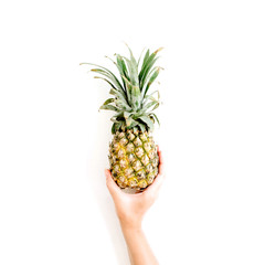 girl's hand holding pineapple. flat lat, top view