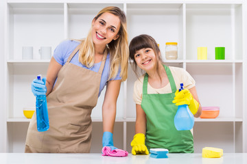 Happy mother and her daughter enjoy cleaning together.