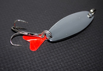 metal lure for catching fish on a black background © kvdkz