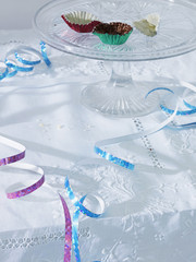 Cup cake wraps amongst streamers on table elevated view