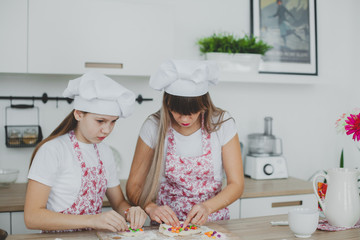 Mother with her daughter are preparing the buns