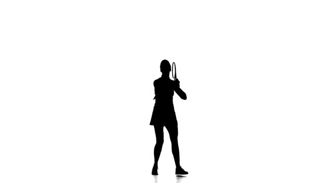 Girl in sportswear jumping and discourage racket ball. Silhouette. White background