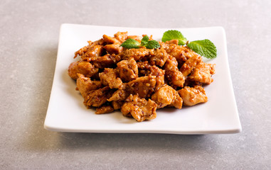 Spicy chicken breast with sesame on plate
