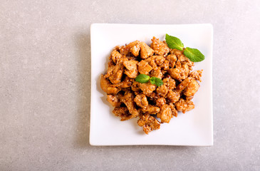 Spicy chicken breast with sesame on plate