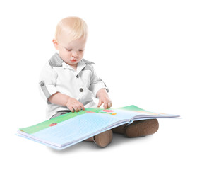 Baby boy with book sitting on white background