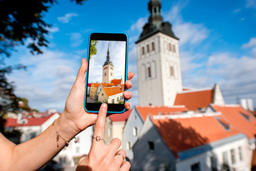Naklejka premium Photographing with smart phone saint Nicholas church in the old town in Tallinn, Estonia