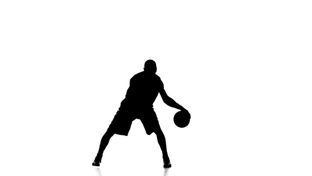 Boy basketball player skillfully handles the ball. Silhouette. White background