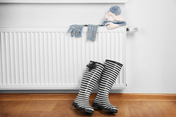 Heating radiator with rubber boots and warm clothes indoor