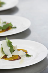 Closeup of three plates of salads with grated cheese