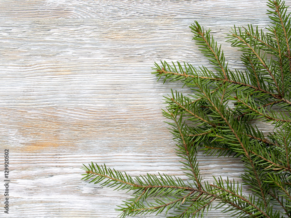 Wall mural Christmas wooden background with fir branches.