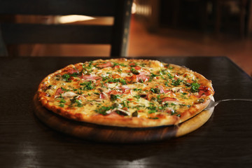 Plate with tasty pizza on wooden table