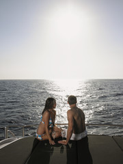 Couple looking at ocean while sitting on yacht during summer