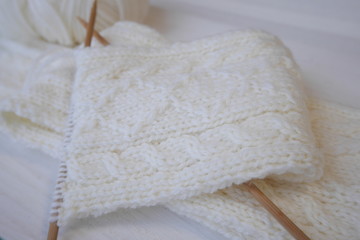 Knitting a woolen scarf with Aran pattern