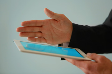 Male finger touching tablet screen on blurred background