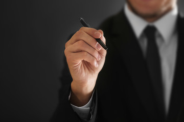 Male hand holding pen, closeup
