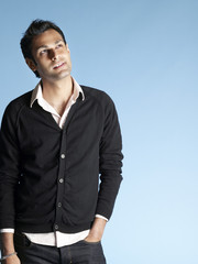 Fototapeta premium Portrait of thoughtful young man looking up at copyspace isolated on blue background