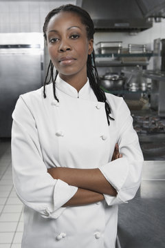 Portrait of a serious female chef with hands crossed in the kitchen