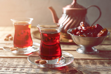 Turkish tea in traditional glasses on wooden table closeup