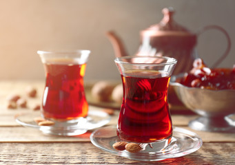 Turkish tea in traditional glasses on wooden table closeup